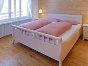 格林德尔瓦尔德Holiday Home Chalet Ahornen by Interhome的客房内的白色床和粉红色枕头