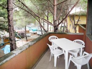 毕博纳的码头Apartment Campeggio del Forte-1 by Interhome的树木繁茂的阳台配有白色的桌椅