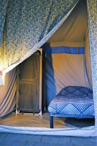 Anna Paulowna4 persoons ingerichte tent op kleine camping的帐篷内一间卧室,配有一张床