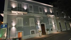莫诺波利Casa Vacanze Gabriele D'Annunzio的白色的大建筑,晚上有白色的门窗