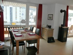 达沃斯伯美那特公寓的一间带木桌和椅子的用餐室
