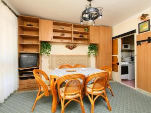 鲍洛托瑙考利Holiday Home Piccola by Interhome的一间带桌椅和电视的用餐室