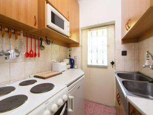 鲍洛托瑙考利Holiday Home Piccola by Interhome的厨房配有白色炉灶和水槽