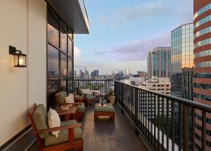 纳什维尔哈顿酒店的阳台配有桌椅,享有城市美景。