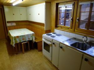 RitzingenApartment Poschthüs Biel-1 by Interhome的厨房配有炉灶、水槽和桌子