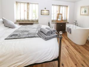 霍姆弗斯Ha'penny Cottage的一间卧室设有一张大床和一个浴缸