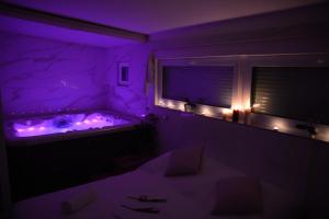 布拉格Wellness Vila Bohemia的紫色客房 - 带紫色灯浴缸