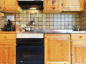 蓬尼亚Apartment Genziana by Interhome的厨房配有木制橱柜和黑烤箱。
