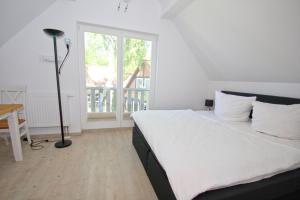 DrewoldkeFerienhaus Cumulus Haus - strandnah, Terrasse, Sauna的一间卧室配有一张床、一张书桌和一个窗户。