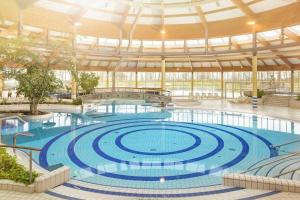 奥斯特巴德·哥伦Terrasse, gratis Nutzung vom AHOI Erlebnisbad und Sauna - Meeresblick FeWo 10的大型建筑中的大型游泳池