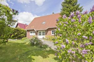 普特布斯Ferienhaus Gisela Gartenblick - Terrasse, Garten, Sauna的院子里布满紫色花的砖房
