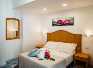 弗卡诺Hotel Rojas的一间卧室,床上放着鲜花