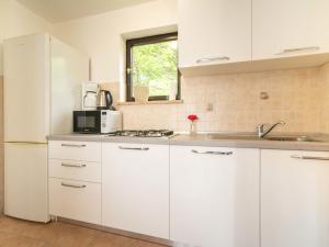 洛夫兰Holiday Home Erminia by Interhome的厨房配有白色橱柜和白色冰箱。