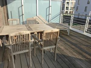 布列登Apartment Residentie Mistral by Interhome的阳台上的木桌和椅子