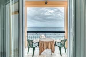 贝尼蔡斯Eros Beach Hotel的海景阳台上的桌椅
