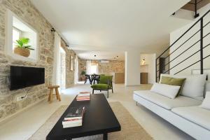 博扎瓦Villa Mira with a heated pool and a sea view的客厅配有白色沙发和电视