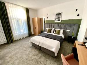 奥拉迪亚Victoria Rooms的酒店客房设有一张大床和一张书桌。