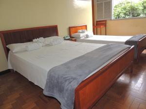 贝洛奥里藏特Hotel Esplanada Belo Horizonte - Proximo a Estacao de Trem的一间卧室设有两张床和窗户。