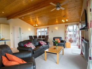 托波因特Finest Retreats - Whitsand Bay Lodge的客厅配有皮革家具和木制天花板