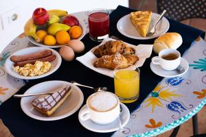 弗卡诺Hotel Rojas的餐桌上摆放着早餐食品和饮料