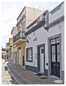 法鲁Casinha da Ti Babel的街道上一扇黑色门的白色建筑