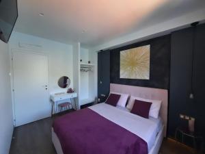 布里维奥Le Luci sul Lago di Como的一间卧室配有一张大床和紫色毯子