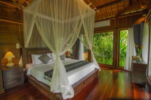 德格拉朗Sebatu Tulen Villa的一间卧室配有一张带天蓬的床