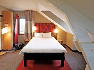 迈松拉菲特宜必思曼森拉斐特酒店的一间卧室配有一张带白色床单的大床