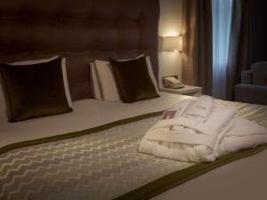 什鲁斯伯里什鲁斯伯里阿尔​​布莱顿大厦美居Spa酒店的一间卧室配有带毛巾的床