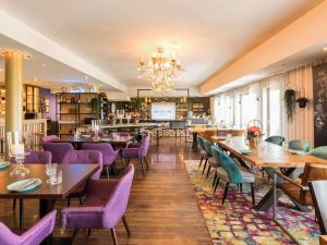巴特恩豪森巴特恩豪森市美居酒店的餐厅设有木桌和紫色椅子
