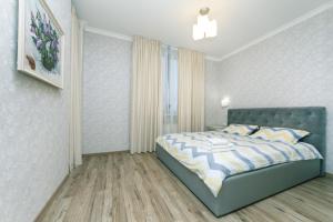 布罗瓦里Квартира VIP класса рядом с Терминалом的一间卧室设有蓝色的床和窗户。