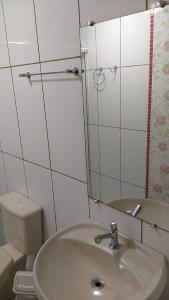 RolanteHotel Pousada Rolantchê的一间带水槽、卫生间和镜子的浴室