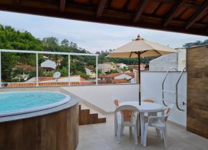 康赛瓦托利亚Pousada do Vovô Luiz的一个带桌椅的庭院和一个游泳池