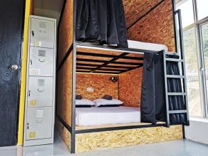 金马仑高原The Cocoon Capsule Hotel的砖墙内的一个房间,配有双层床