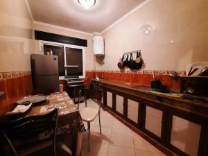 丹吉尔Appartement Tanger的厨房配有柜台、桌子和冰箱。