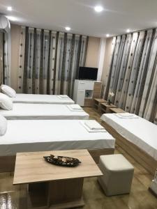 阿塞诺夫格勒Каламанди的酒店客房设有三张床和一张桌子