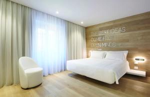 的里雅斯特YouMe Design Place Hotel的卧室配有白色的床和白色椅子