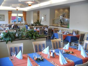 斯拉德明Hotel Sonneck的一间配备有桌椅及蓝餐巾的用餐室