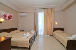 乐托卡亚Akrothalassia的酒店客房设有两张床和窗户。