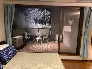 热海热海温泉惠旅馆的一间卧室享有带桌椅的庭院的景致。