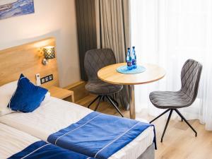 米科瓦伊基Cobalt Apartments的酒店客房带一张床、一张桌子和椅子