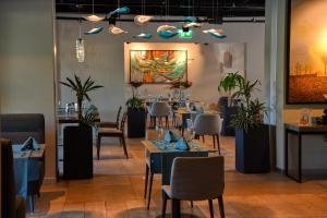 伊斯坦布尔Antwell Suites的餐厅设有桌椅,墙上挂有绘画作品