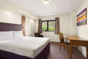肯德尔戴斯肯达尔酒店 - 肯灵顿湖的配有一张床和一张书桌的酒店客房