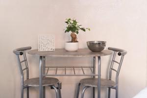 卡塔尼亚Suite Vico li cuti的一张桌子,上面有两把椅子和一株植物