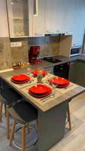 萨图马雷Katy Boulevard Apartman的一张厨房桌子,上面有红盘和玻璃杯
