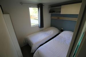 贝尔多夫Loggia Camping Belle-Vue 2000的小型客房 - 带2张床和窗户