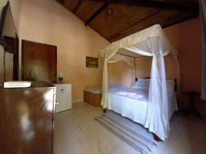 迪奥戈Recanto Verde - Praia de Santo Antônio的一间卧室配有一张带天蓬的床