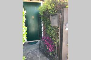 米拉Barchessa Ca’ Leon sul naviglio del Brenta的绿色门入口,带粉红色花卉