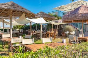 阿布鲁齐的罗塞托Case vacanze Blue Bay Resort的一间带桌椅和遮阳伞的餐厅