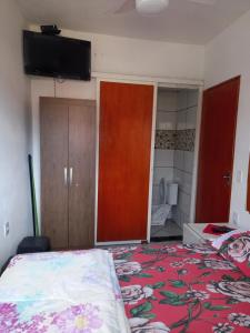 圣托梅-达斯莱特拉斯Apartamento avenida 07的卧室配有一张床,墙上配有电视。